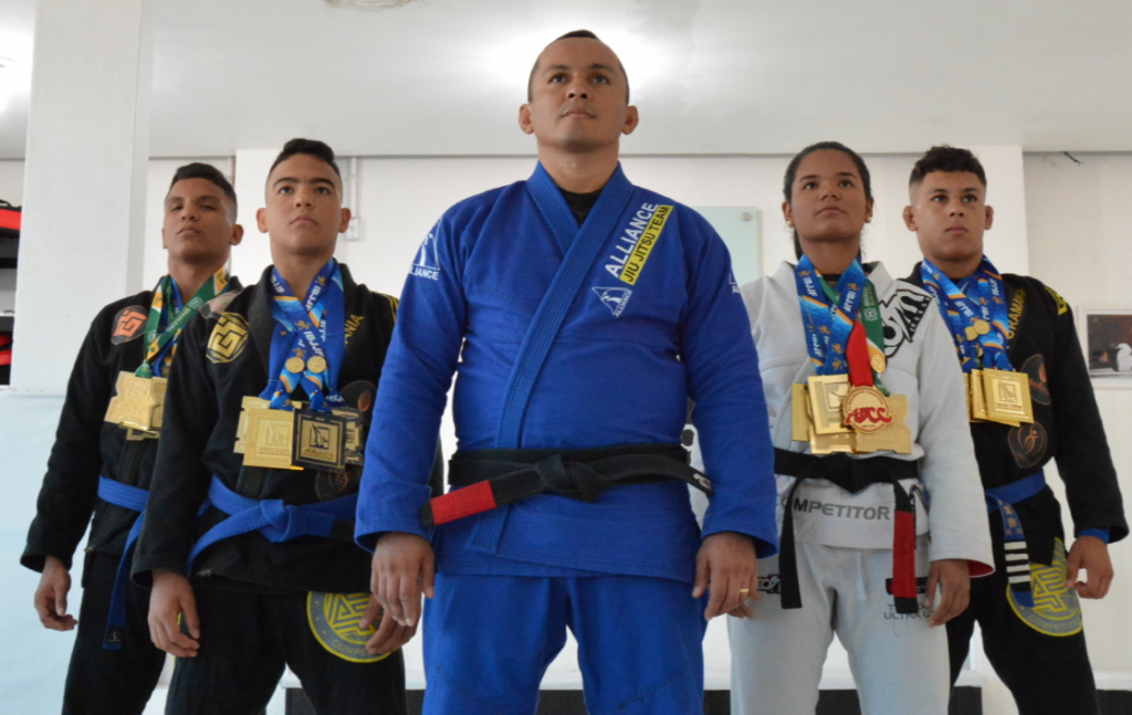 Melqui Galvão com atletas e medalhas na academia