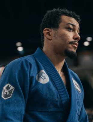 Erich Munis de kimono azul em competicao de Jiu-Jitsu