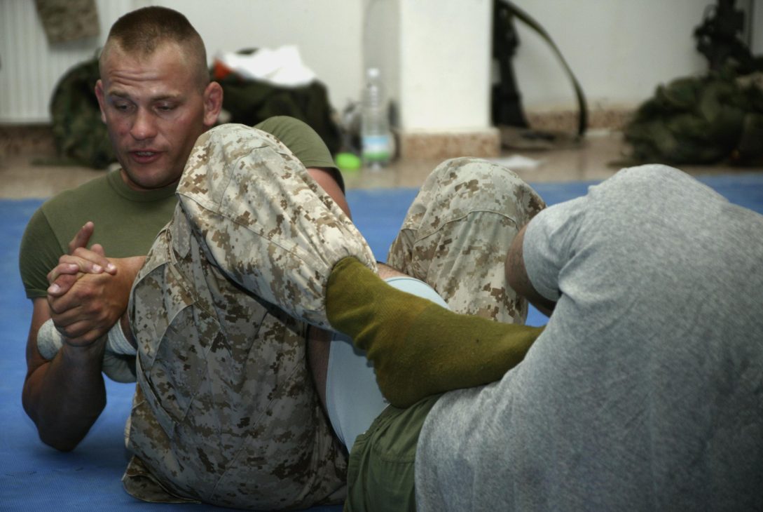 Atleta aplicando controle de perna e tornozelo, entrada de heel hook (chave de perna)