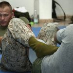 Atleta aplicando controle de perna e tornozelo, entrada de heel hook (chave de perna)