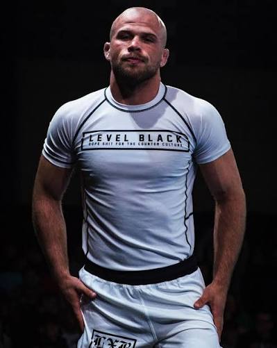 Izaak Michell de rashguard branco Level Black em evento de No-Gi