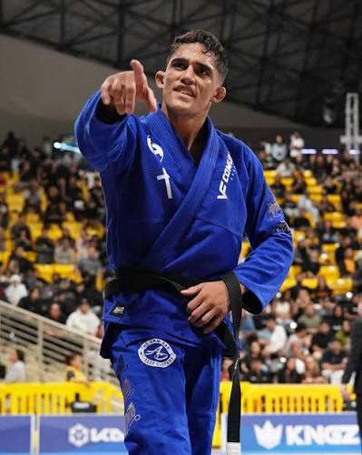 Tarcisio Damasceno Santos comemora apontando para a torcida de kimono azul